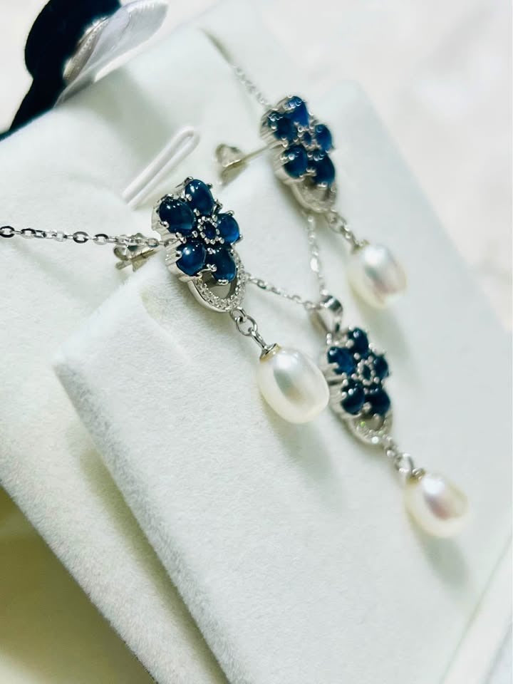Close-up of a natural blue sapphire and pearl jewelry set, featuring necklace and earrings.
