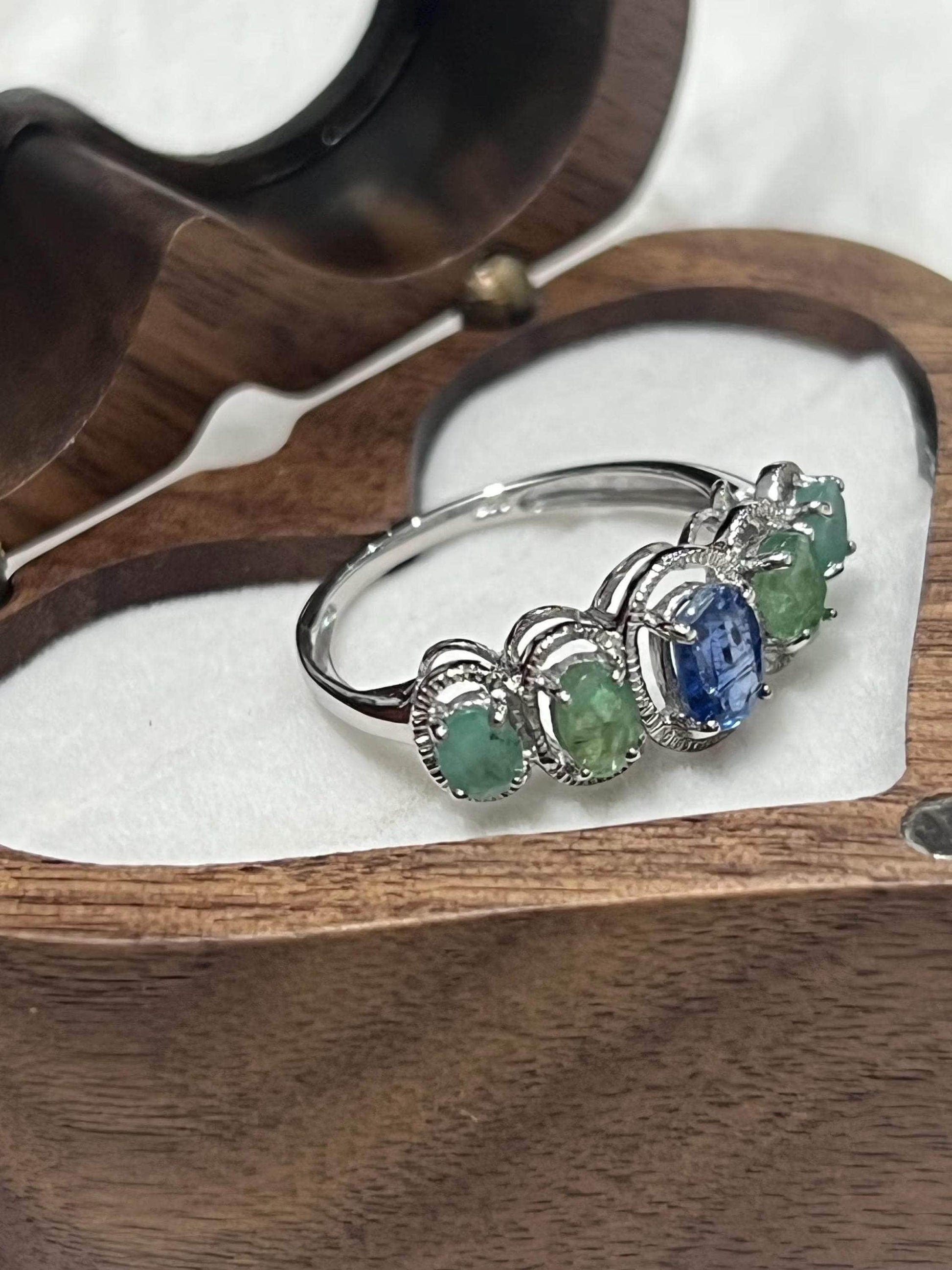 Angled view of the Bochic Kyanite and Colombian Emerald ring in a heart-shaped display box.