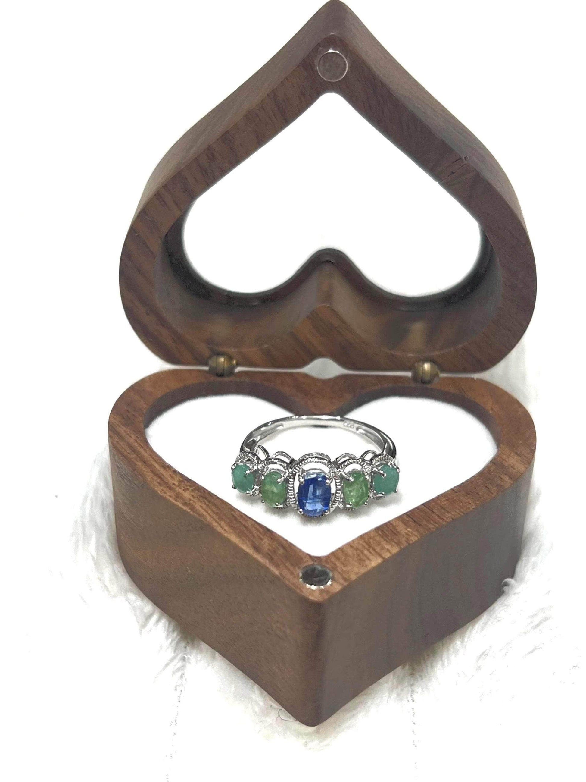 Full shot of the Bochic Kyanite and Colombian Emerald ring elegantly displayed in its open heart-shaped box.