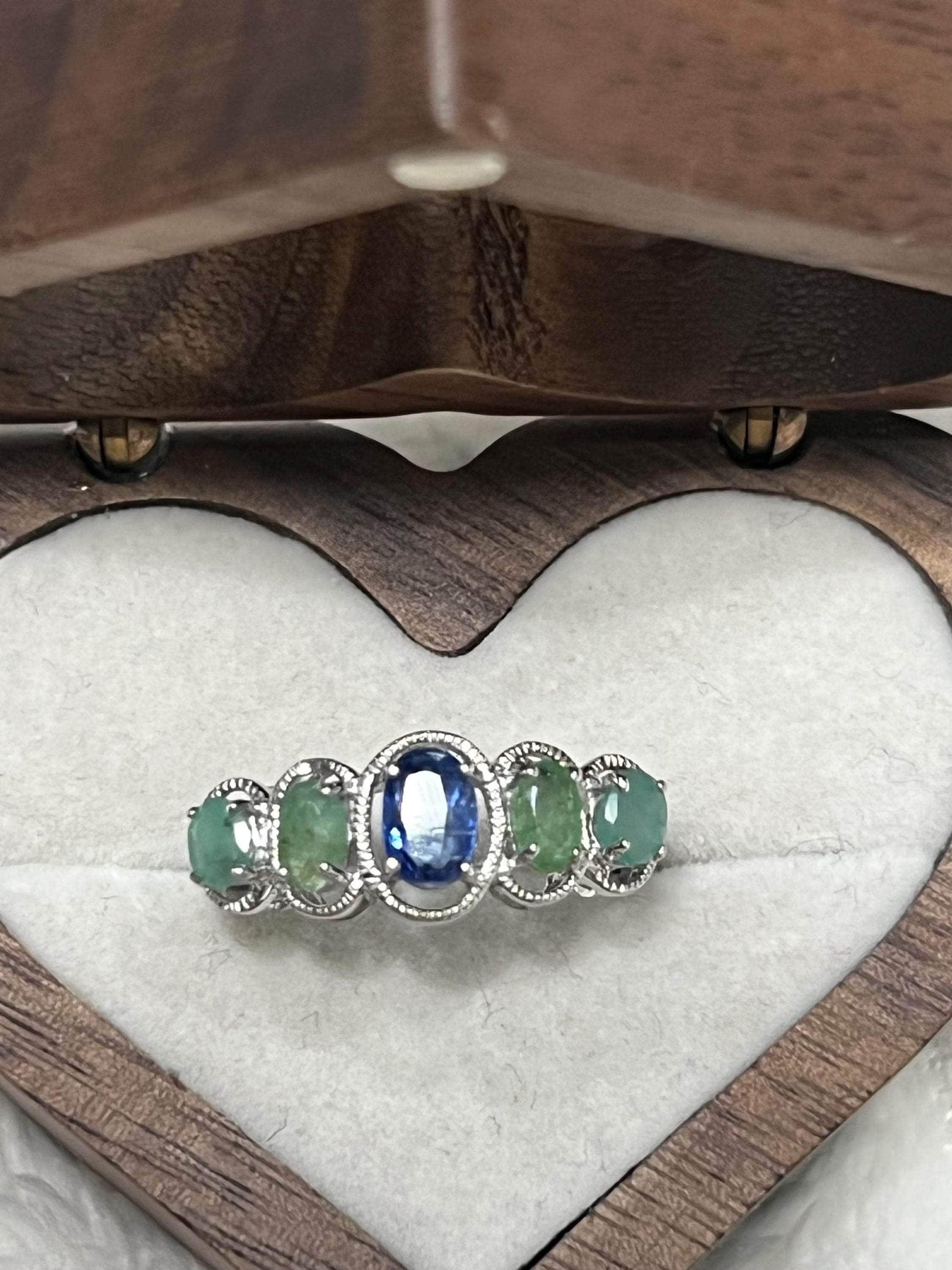 Top view of the Bochic Kyanite and Colombian Emerald ring, highlighting its rich colors within a heart box.