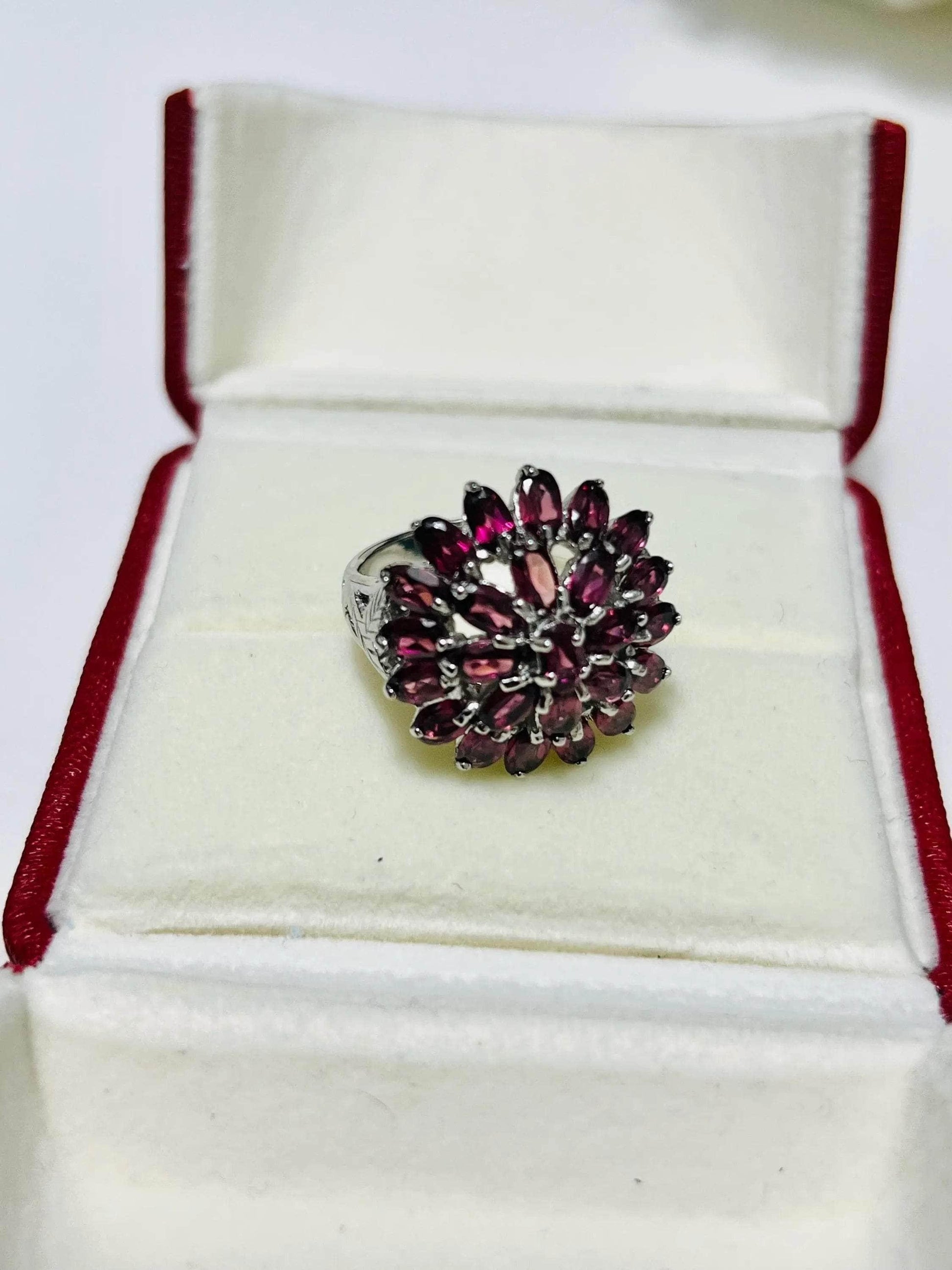 Bochic vintage rhodolite garnet ring nested in its white and red display box, viewed from a slight angle.