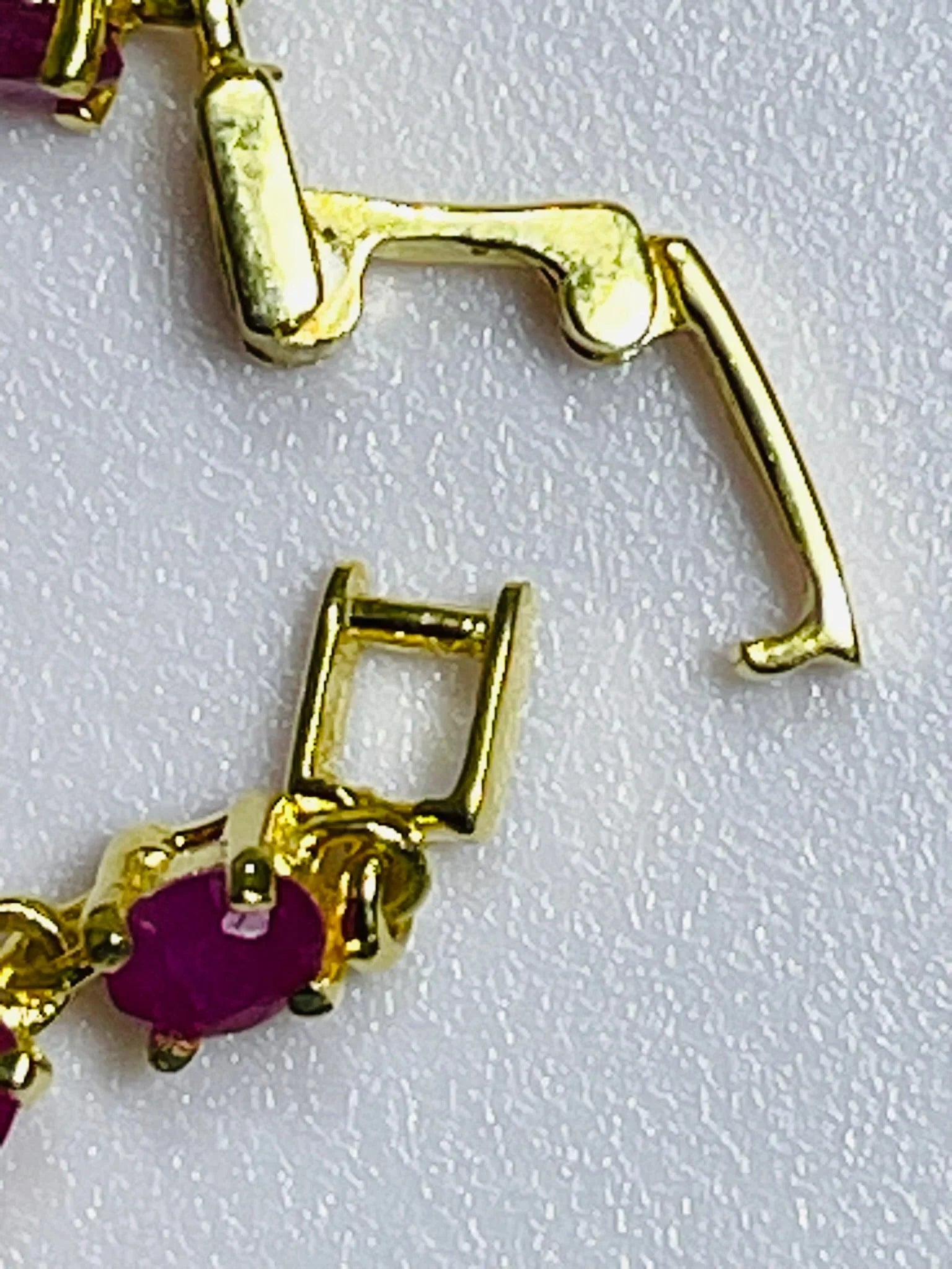 Detailed macro view of a polished gold bracelet clasp, highlighting its robust and secure interlocking mechanism.