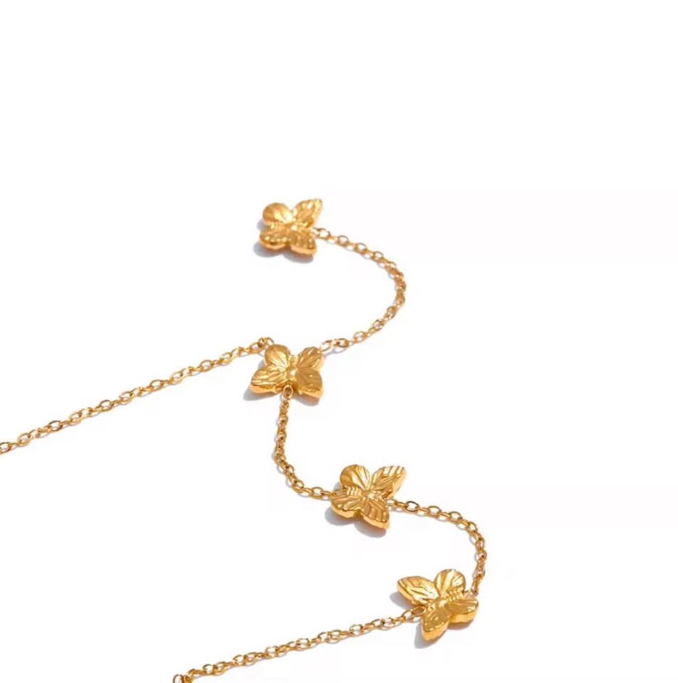  Close-up of intricate gold butterfly charms on an 18k gold vermeil Papillon D'Or necklace.