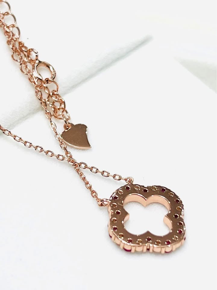 Stylish rose gold clover pendant necklace, highlighting the adjustable chain and heart tag detail.