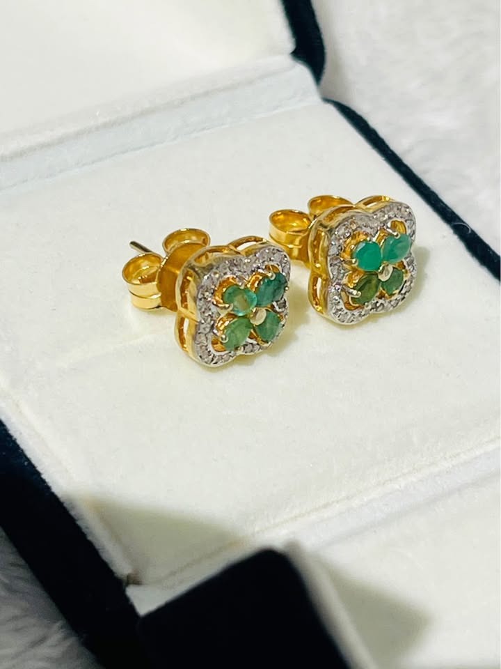 Pair of dazzling Colombian emerald and diamond earrings nestled in a presentation box, ready for wear.