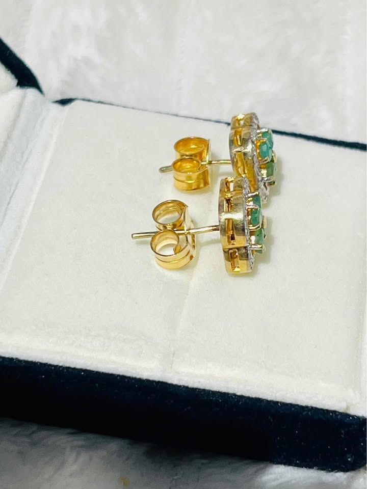 Side view of Colombian emerald and diamond stud earrings, highlighting their gold setting and secure backings.