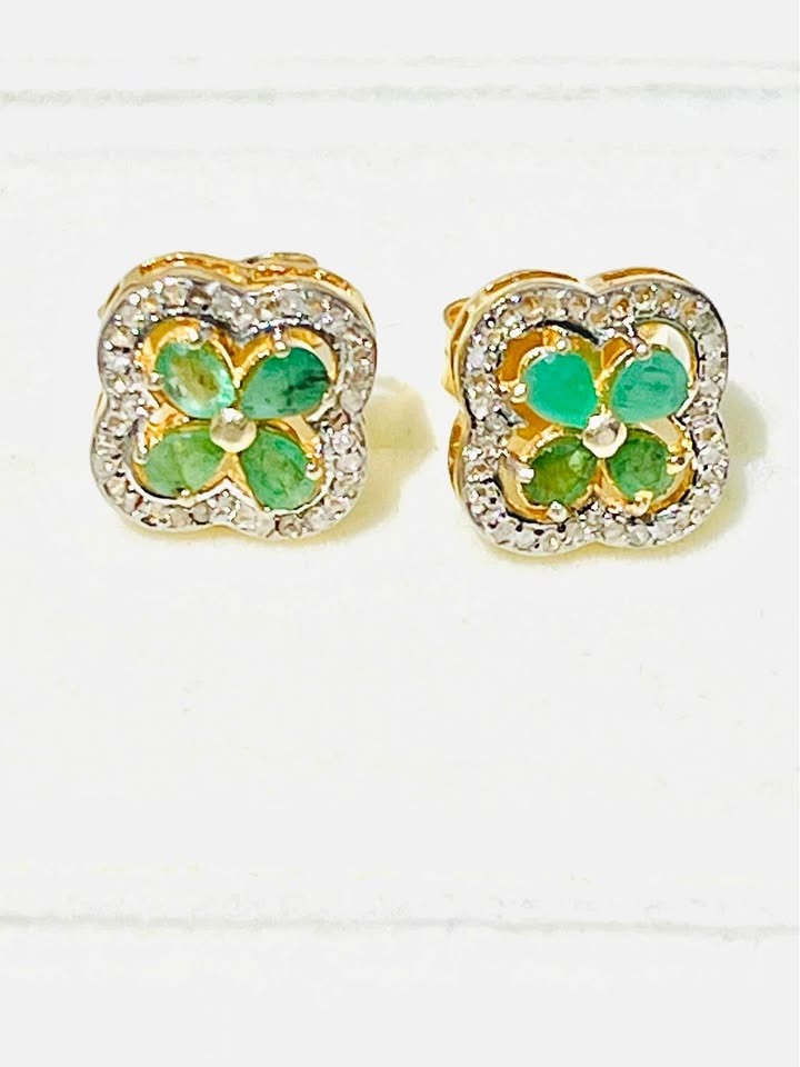 Sparkling Colombian emerald and diamond flower stud earrings displayed on a clean white background.