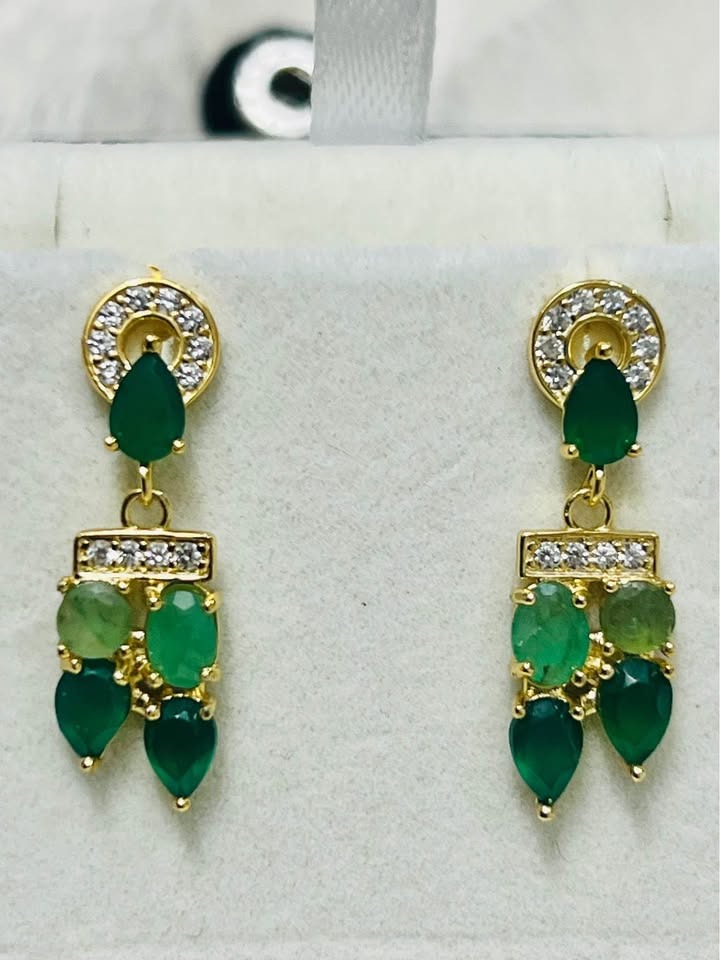 Stunning natural Colombian emerald earrings, gold-tone setting with clear stones, on a white background.