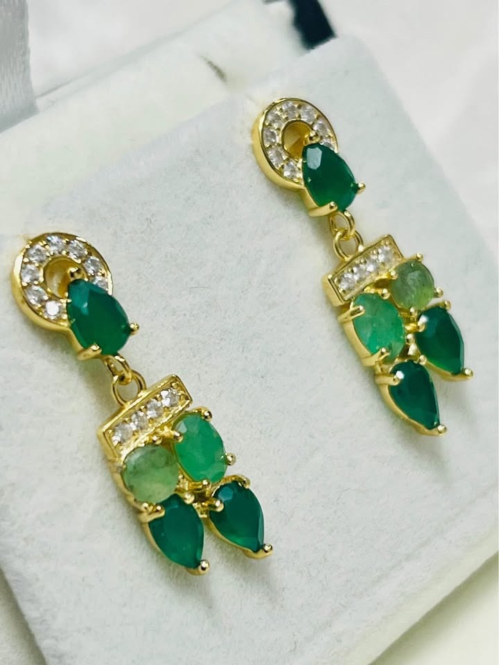  Side view of luxurious natural Colombian emerald earrings with gold-tone setting and clear stones.