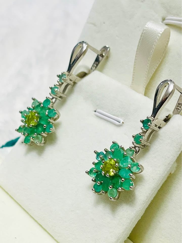Close-up of natural Colombian emerald and peridot floral cluster earrings in sterling silver, showing intricate detail.