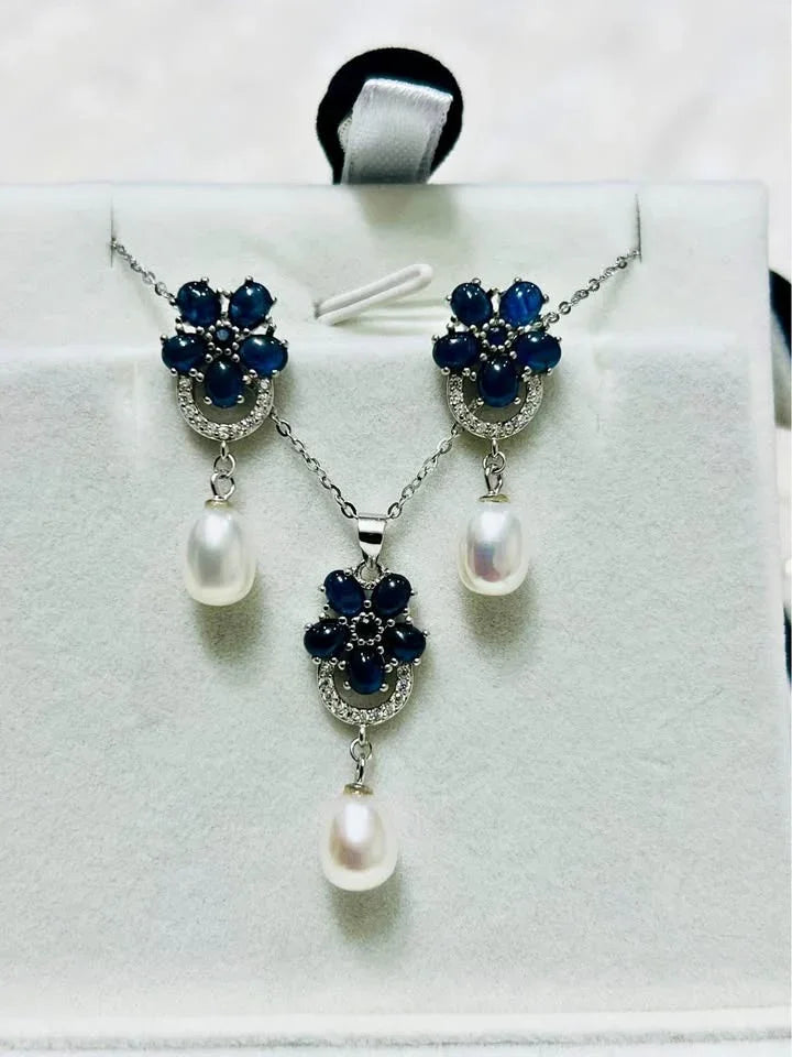 Full view of an elegant natural blue sapphire and pearl jewelry set with matching necklace and earrings.