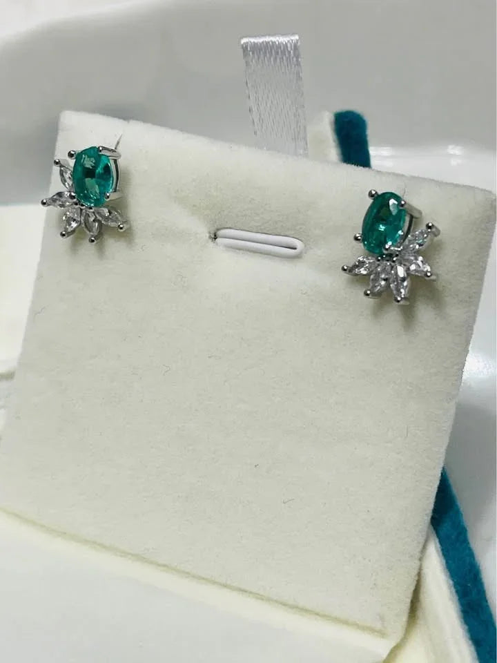 Elegant flower-design stud earrings. These sterling silver earrings showcase sparkling green paraiba tourmaline stones.