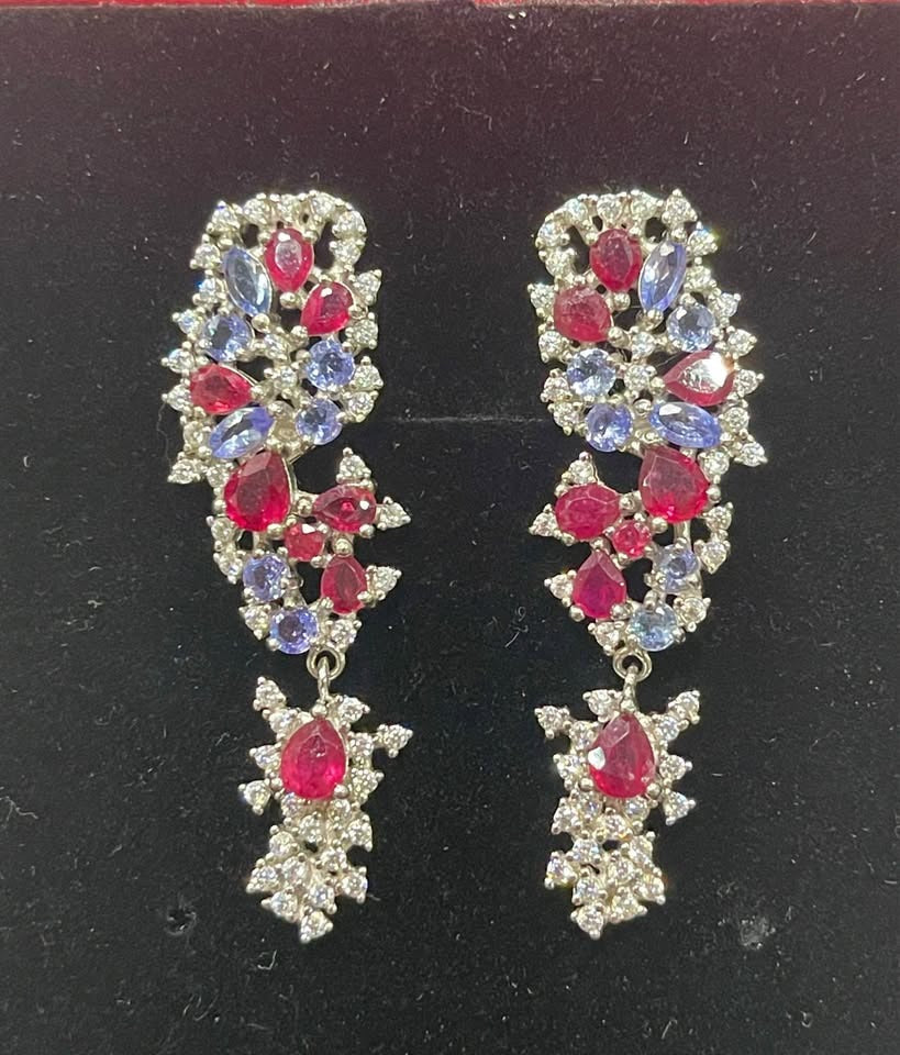 Elegant dangle earrings featuring marquise-cut tanzanite and pear-cut ruby gemstones. A beautiful statement piece.