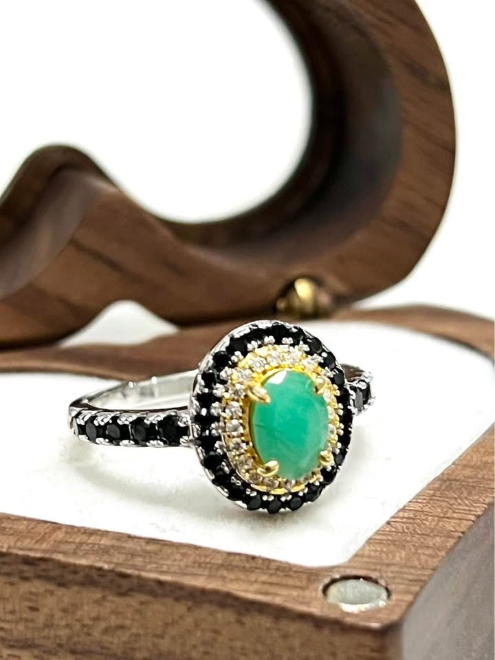 Close-up of genuine emerald, black spinel, two-toned gold/silver ring for unique style.