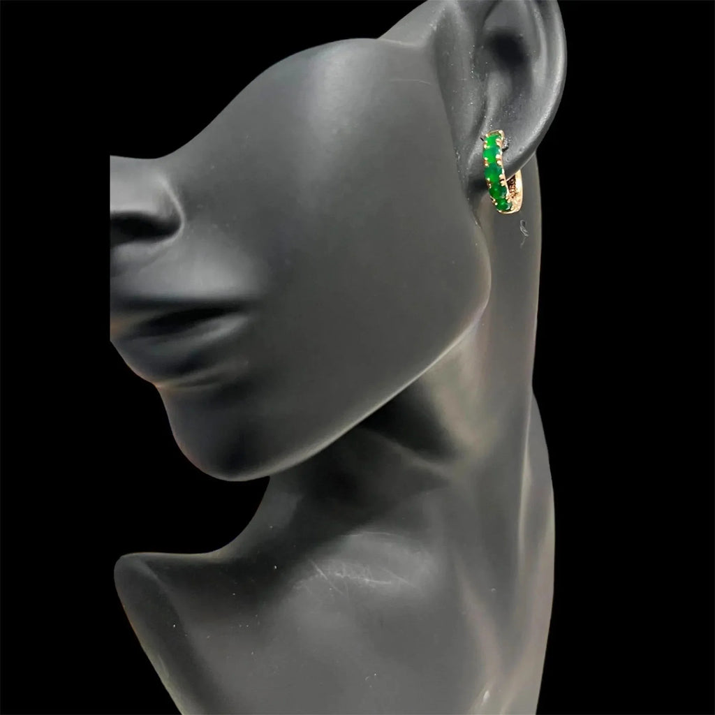 Dainty round-cut emerald hoop earring in rose gold displayed on a black mannequin, showing its scale.