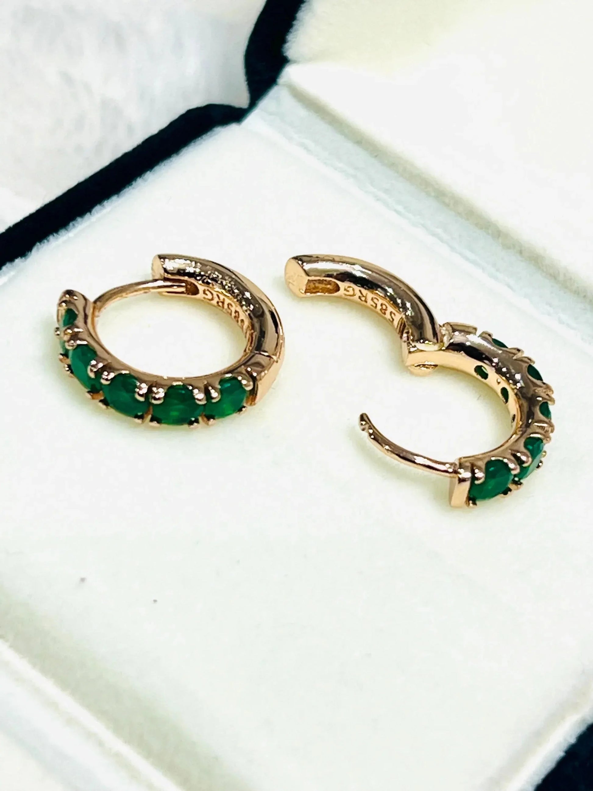 Open and closed view of dainty round emerald hoop earrings in rose gold, highlighting their clasp.