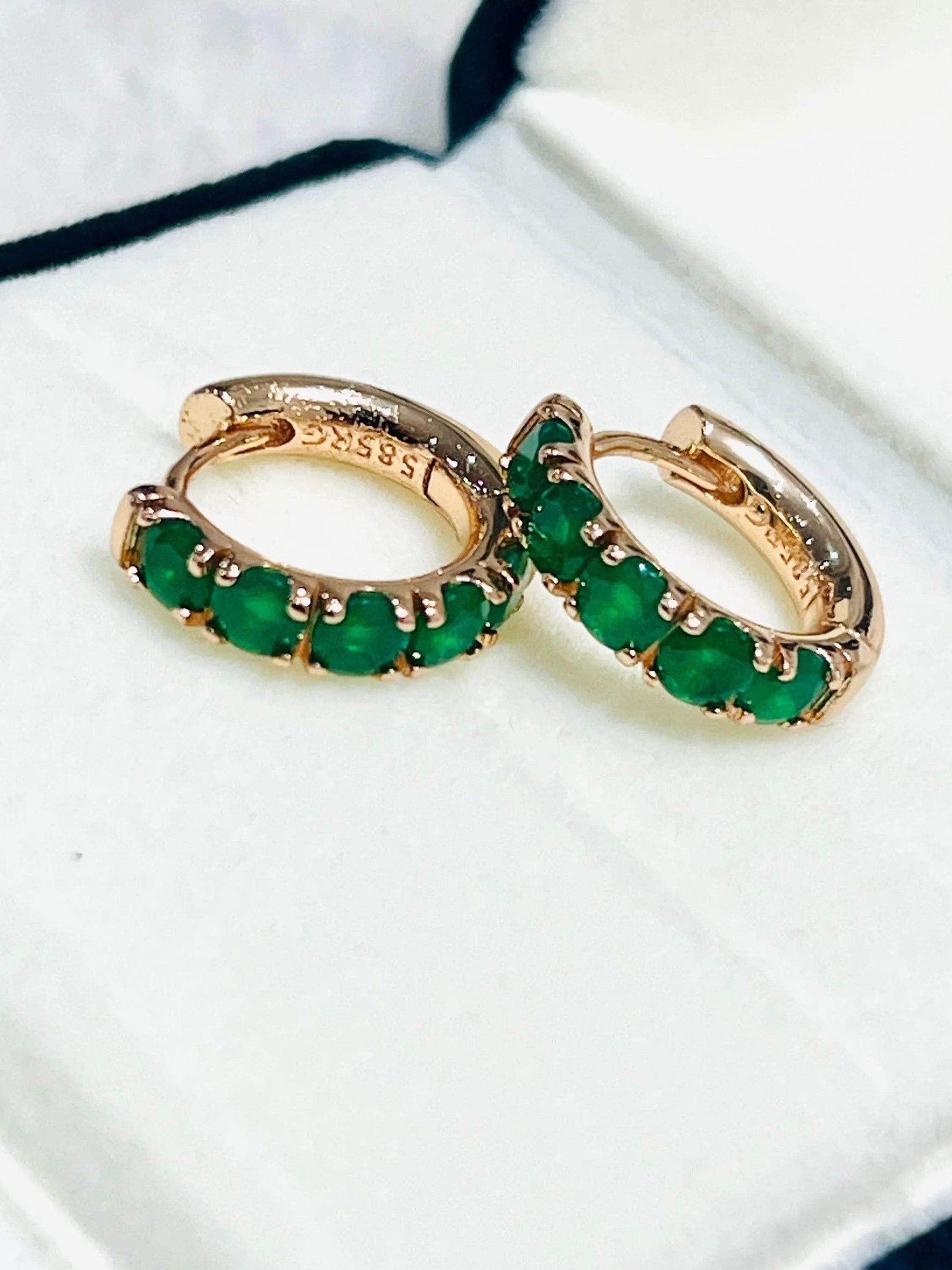 Set of elegant dainty round emerald hoop earrings in rose gold, showcasing their vibrant green gems.