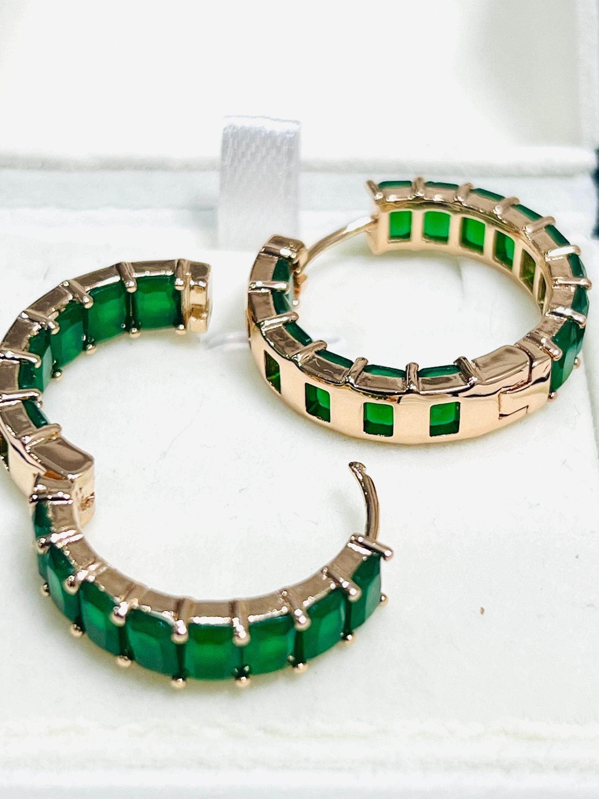Detailed view of emerald matrix hoop earrings, showing the open clasp mechanism and gold-tone setting.