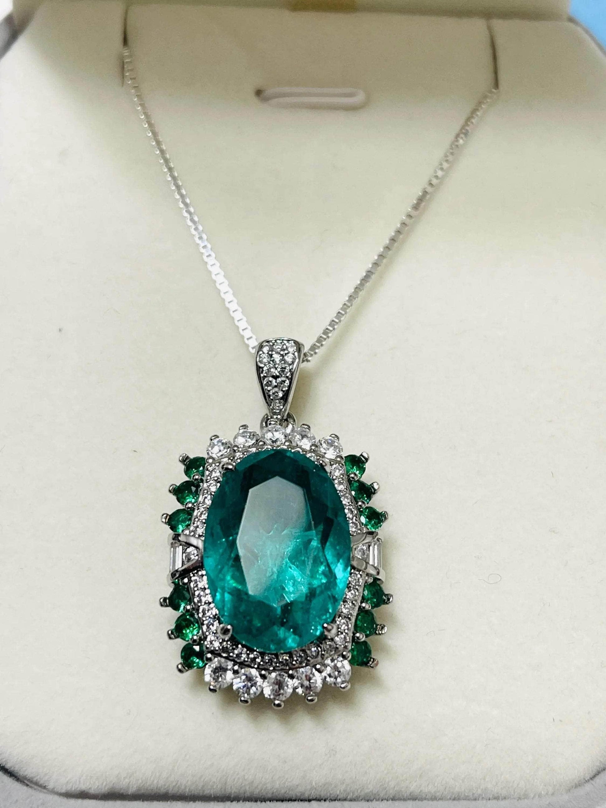 Lab-created emerald pendant necklace in Italian sterling silver with sparkling clear and green accents, displayed in a box.