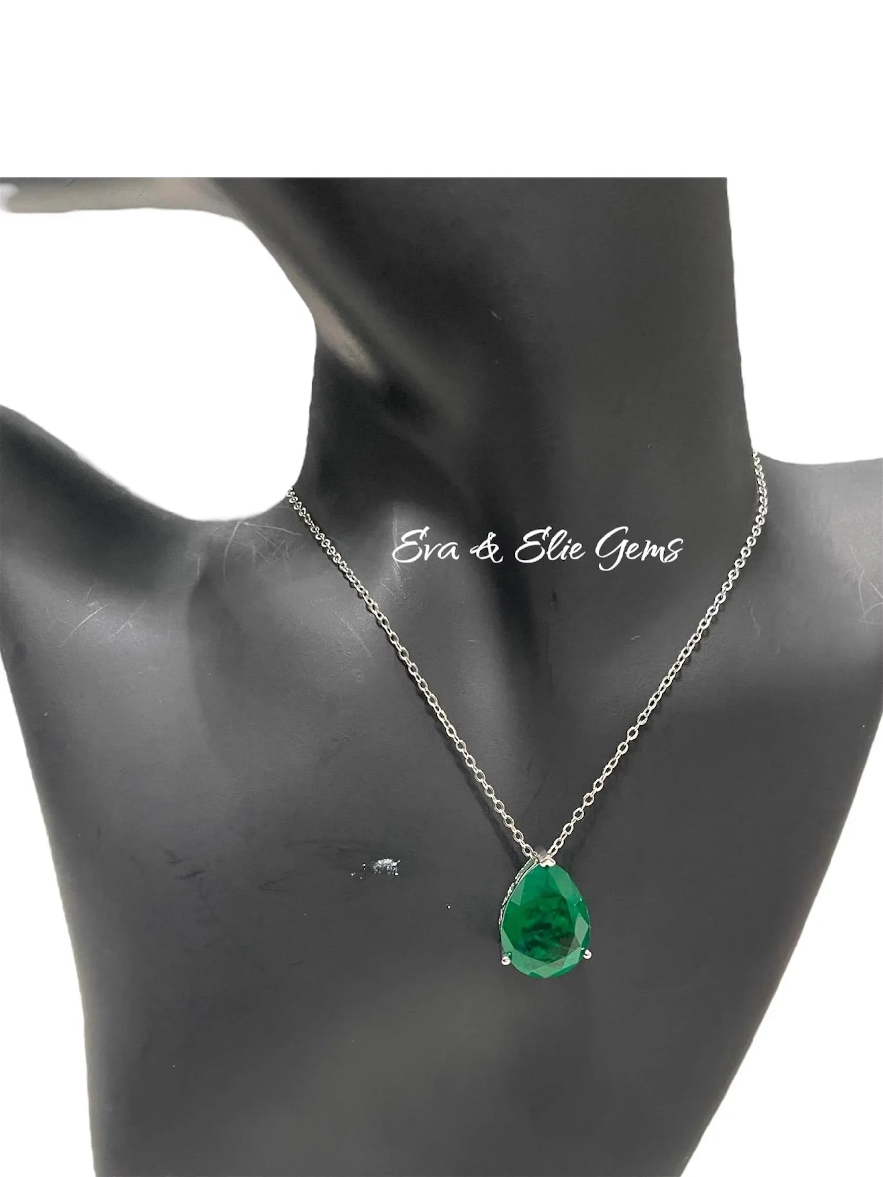 Pear-shaped Zambian emerald doublet pendant necklace displayed on a black jewelry mannequin.