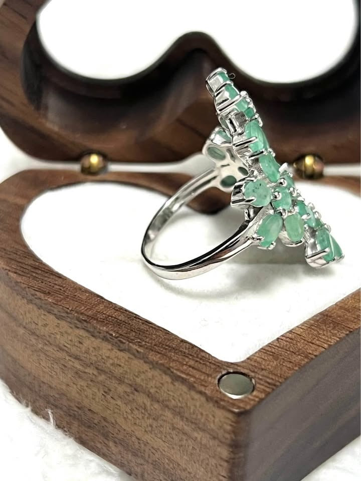 Side profile of a sterling silver ring featuring multiple natural Colombian emeralds, showcasing its unique design.