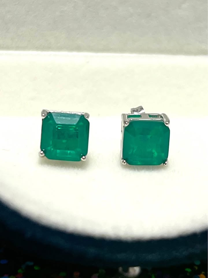 Close-up of dainty genuine emerald square stud earrings in sterling silver, highlighting their vibrant green hue.