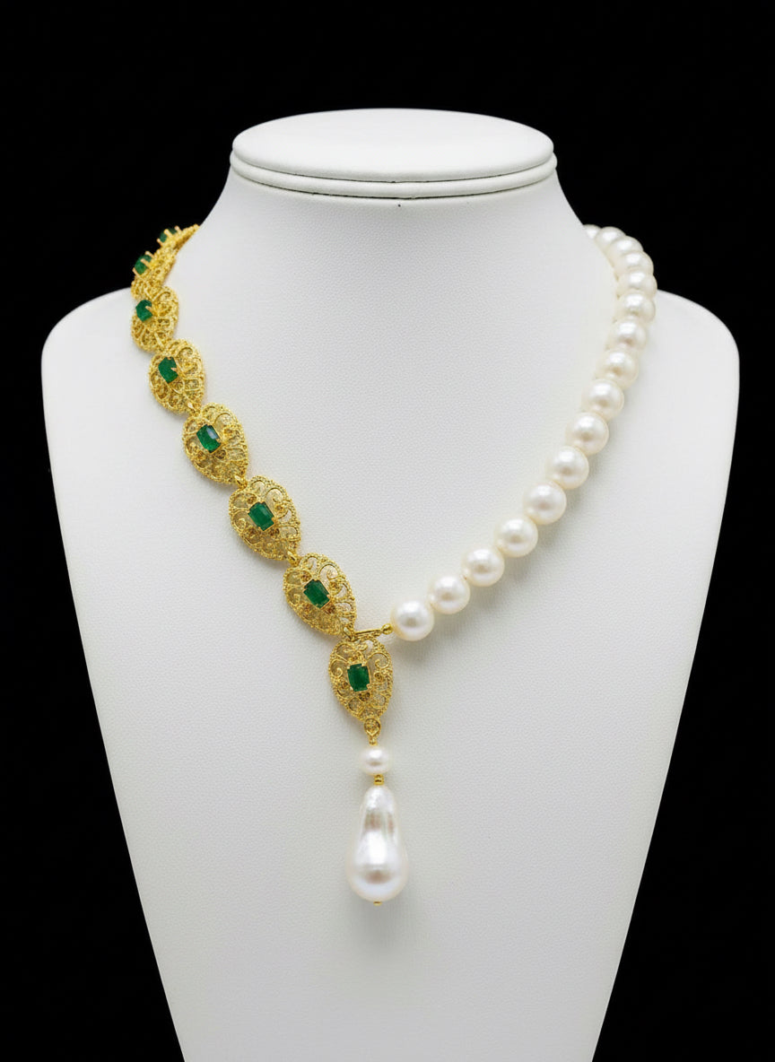 Exquisite emerald and gold accent necklace with South Sea pearls, showcased on a black background.
