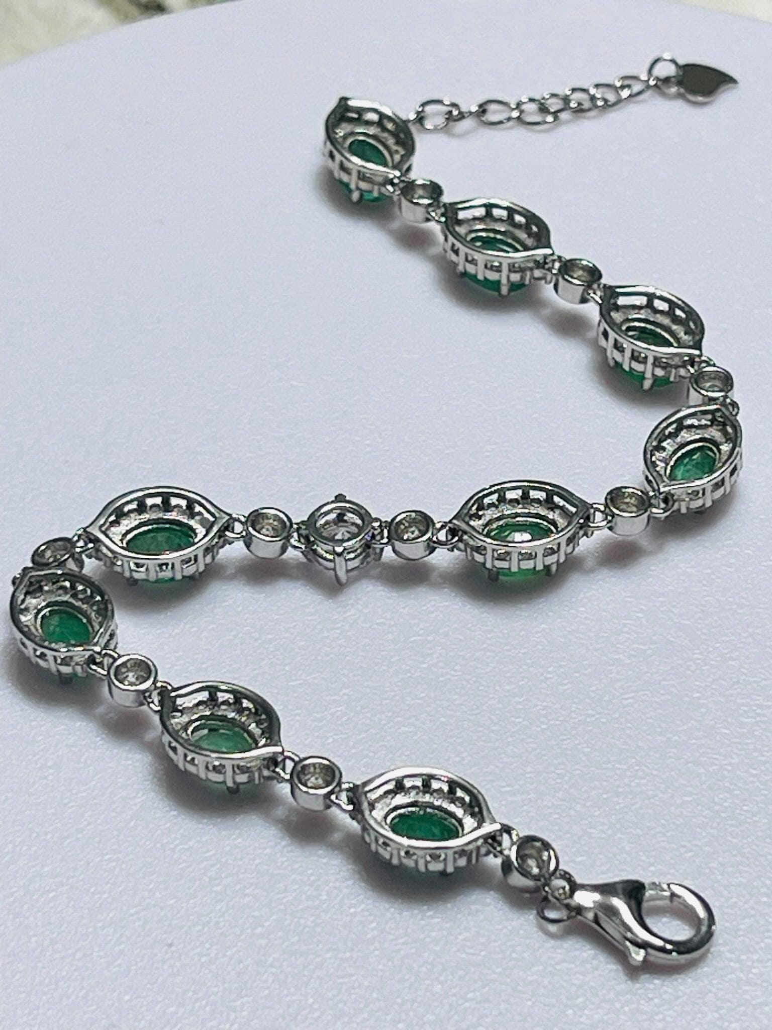 Handcrafted sterling silver bracelet, showing natural Colombian emerald settings and lobster clasp