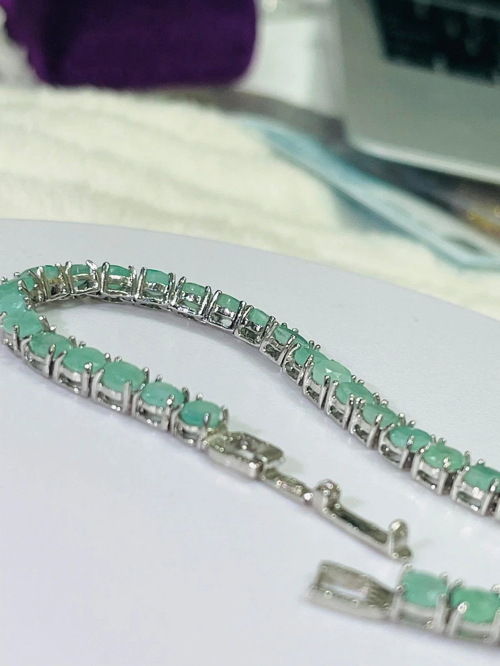 Silver emerald tennis bracelet with continuous line of round, vibrant green stones