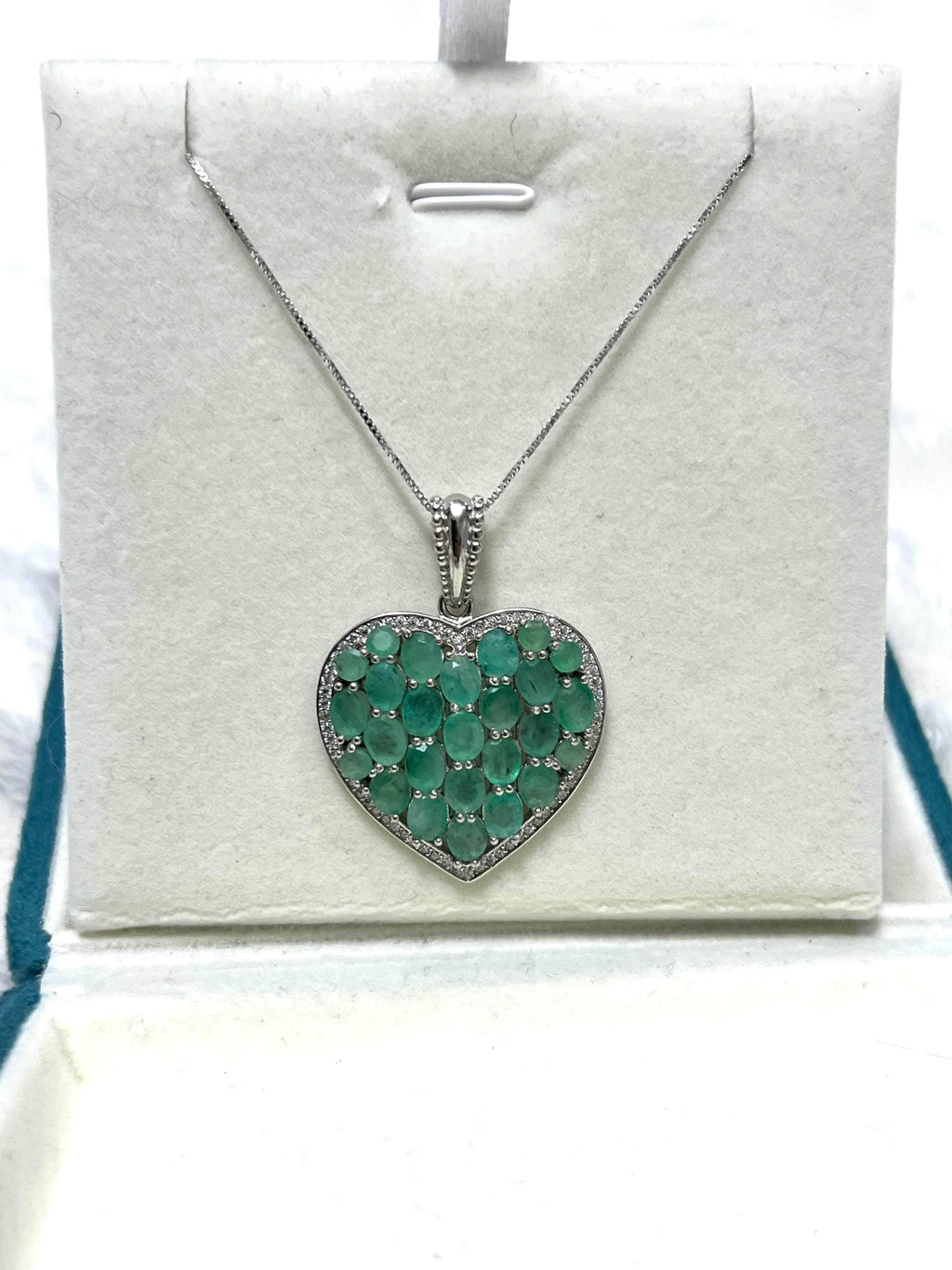 Luxurious 925 sterling silver heart pendant with 7 carat Colombian emeralds and diamonds, presented in a white gift box.