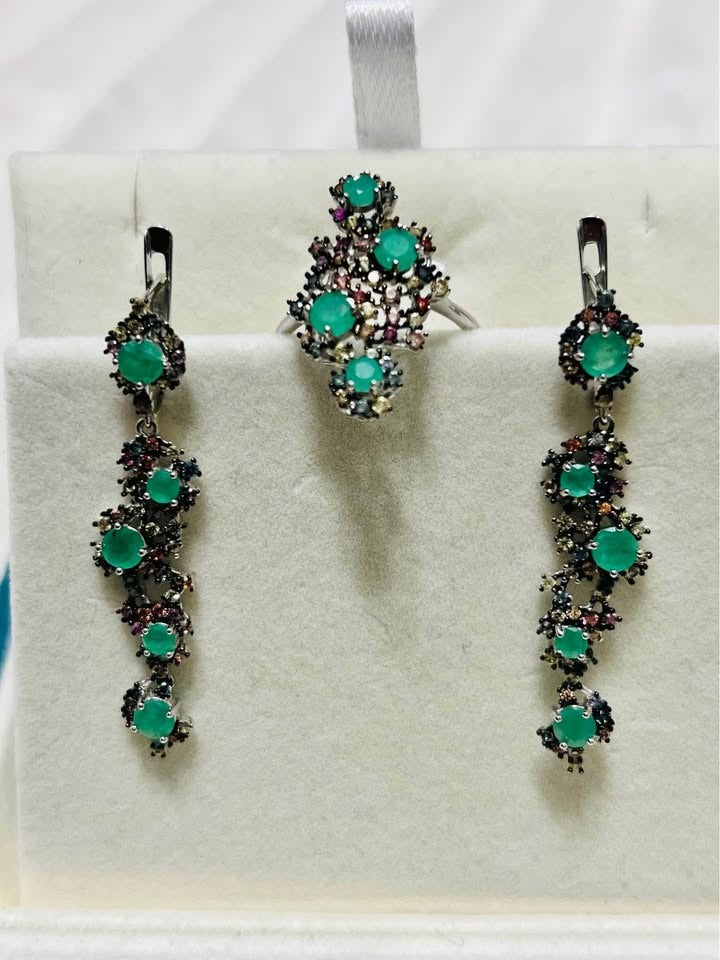 Elegant jewelry set: natural Colombian emerald ring and complementary sapphire-accented drop earrings.