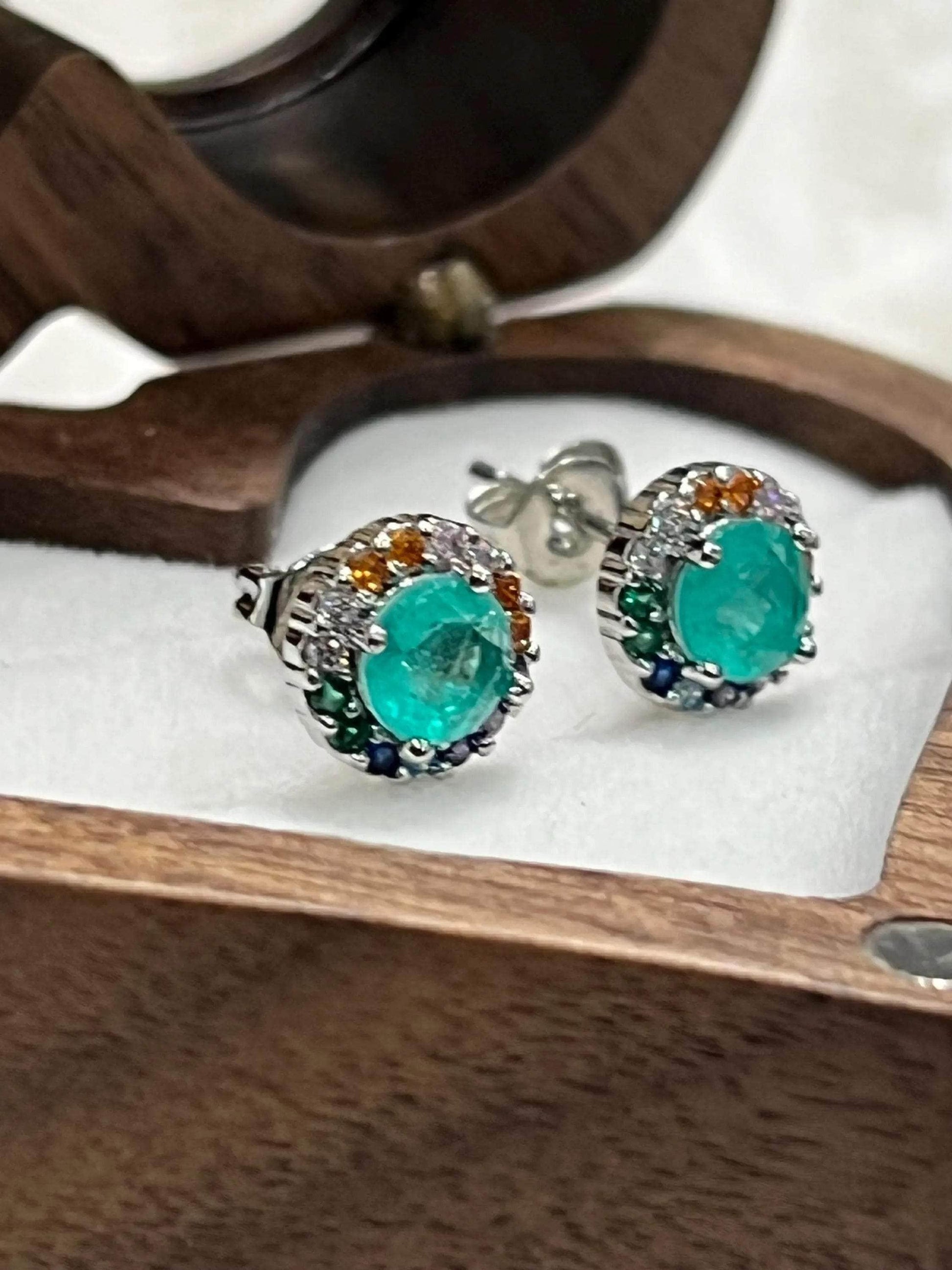Detailed view of faceted Paraiba Tourmaline studs with a bright, colorful gemstone halo.