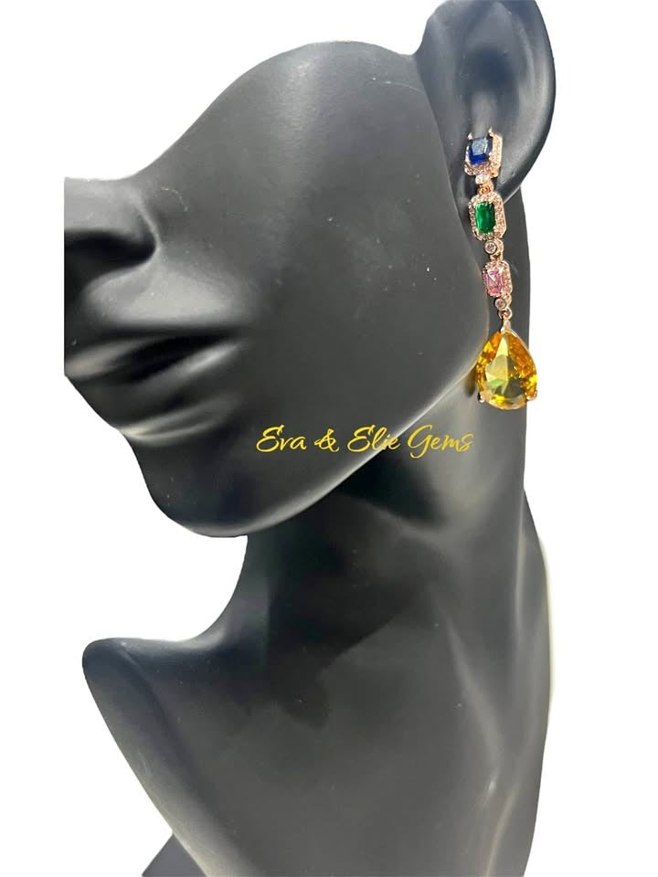 A mannequin modeling a beautiful long dangle earring with a mix of colorful gemstones on a white background.