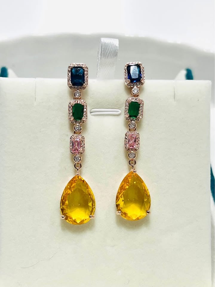  Stunning long dangle earrings with multiple colored gemstones in a cascade design on a white display.