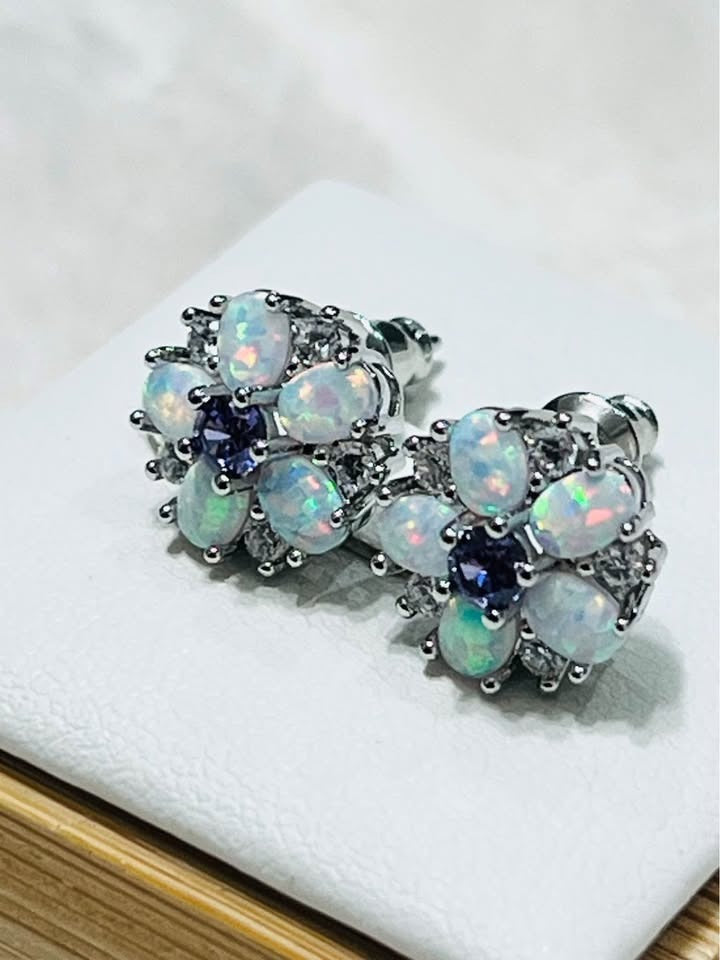 Side profile of fire opal and amethyst dainty stud earrings, showing the secure earring backs and floral design.