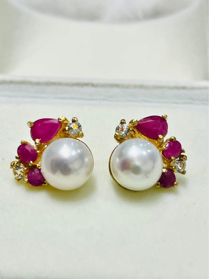  Close-up front view of stunning artisan South Sea pearl earrings with rich rubies and clear white topaz.