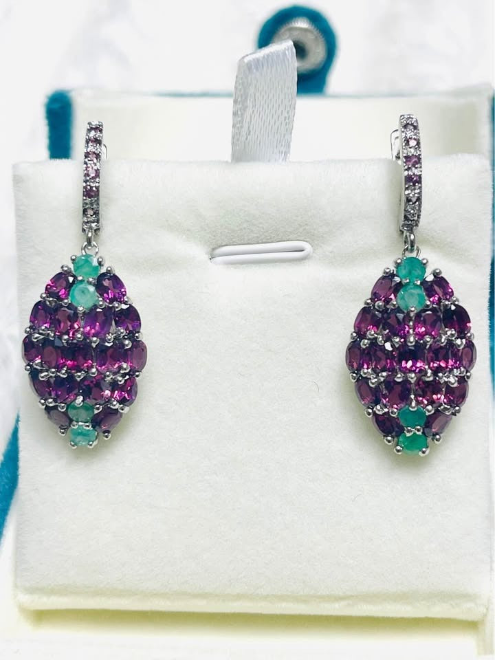 Silver dangle earrings featuring a beautiful cluster design of vibrant rhodolite garnet and emeralds.