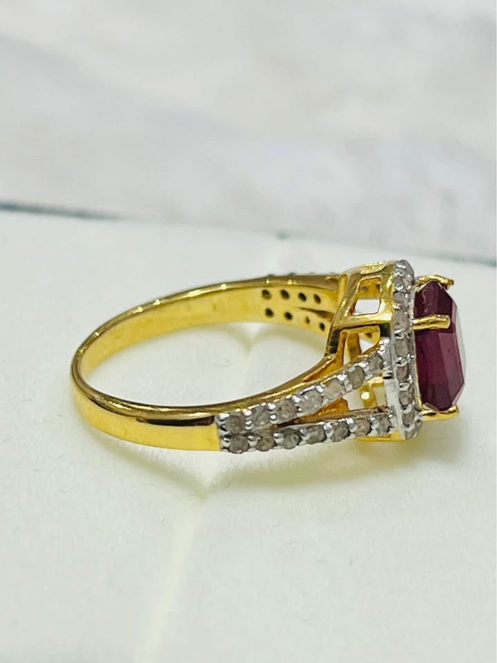 Side profile of a genuine ruby and natural diamond ring in gold on a white setting.