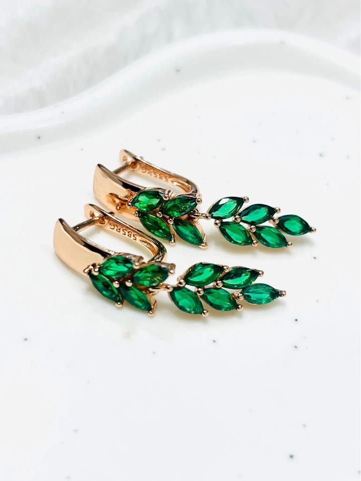 A pair of 14k gold-filled earrings with marquise-cut green topaz, crafted in a graceful leaf-shaped dangle.