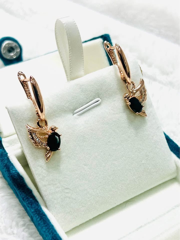 Pair of elegant 14K gold-filled dove earrings featuring black onyx stones, presented in a gift box.