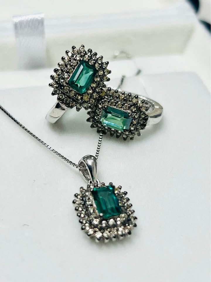  An elegant green tourmaline and diamond jewelry set including a pendant and rings, captured from an angle.