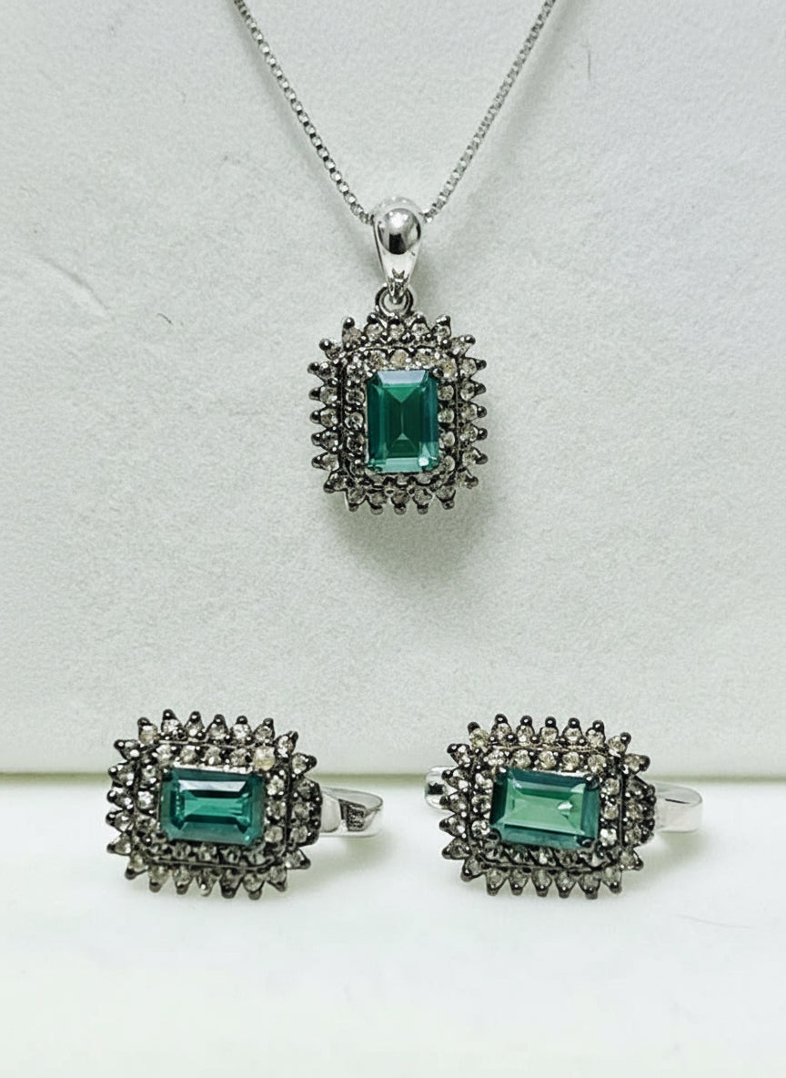 Beautiful green tourmaline and diamond jewelry set, including a pendant and two rings, elegantly displayed.