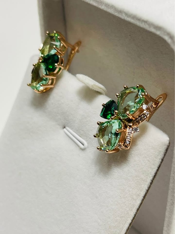 14k rolled gold butterfly earrings with vibrant green and light green gemstones in a jewelry box.