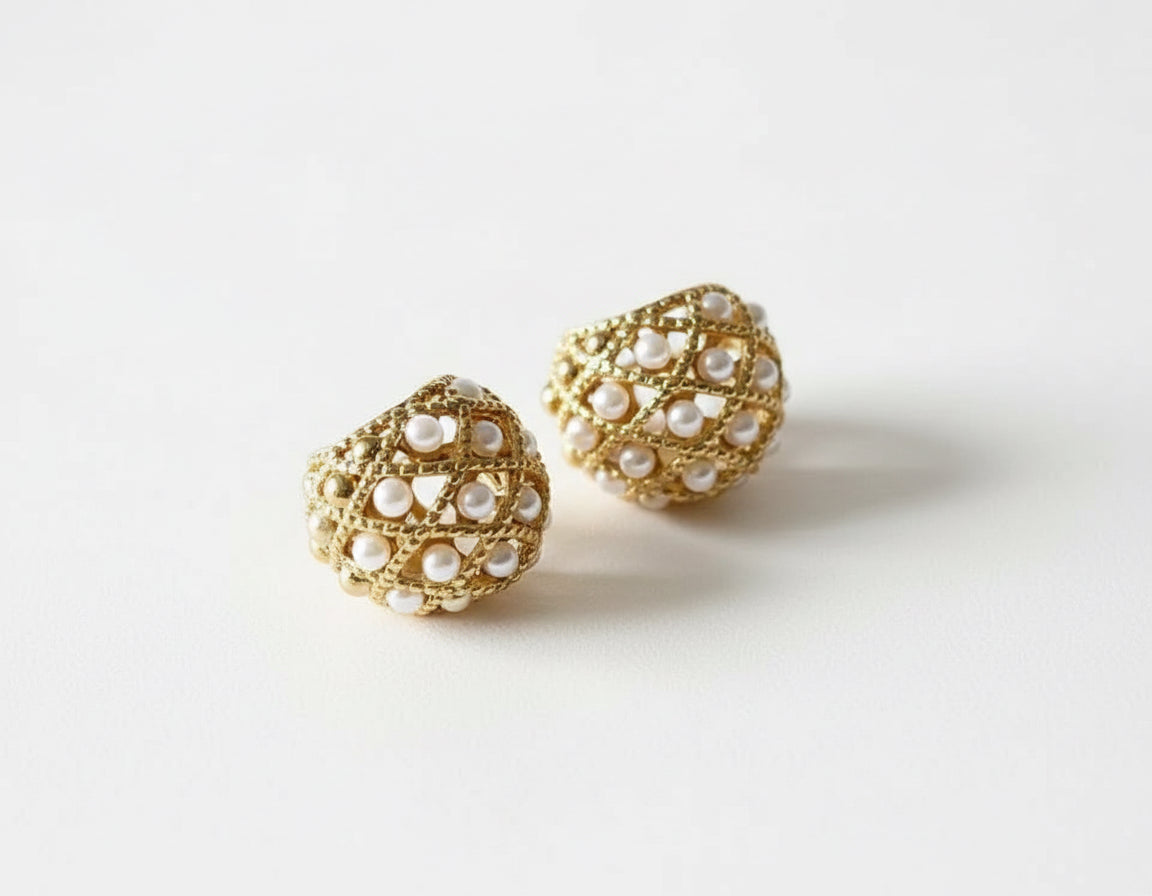 A pair of small, handcrafted 18k gold-filled hoop earrings, each adorned with a fine line of seed pearls.