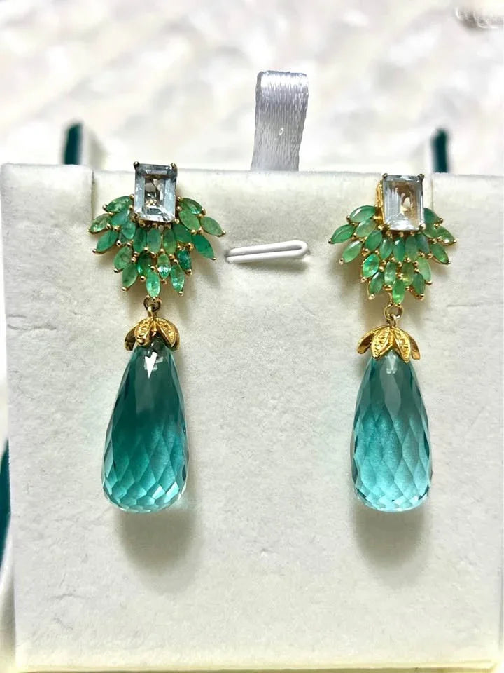  A high-end pair of dangle earrings. Features a rectangular topaz and a cluster of emeralds with large aquamarine drops.