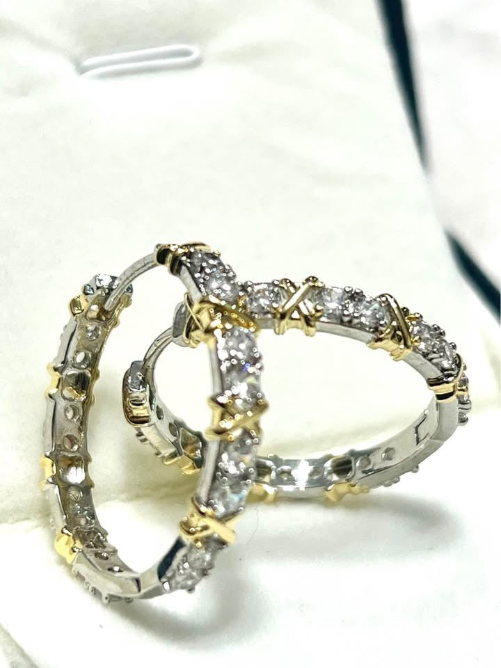  Intertwined pair of XOXO gold plated silver hoop earrings with clear gemstones.