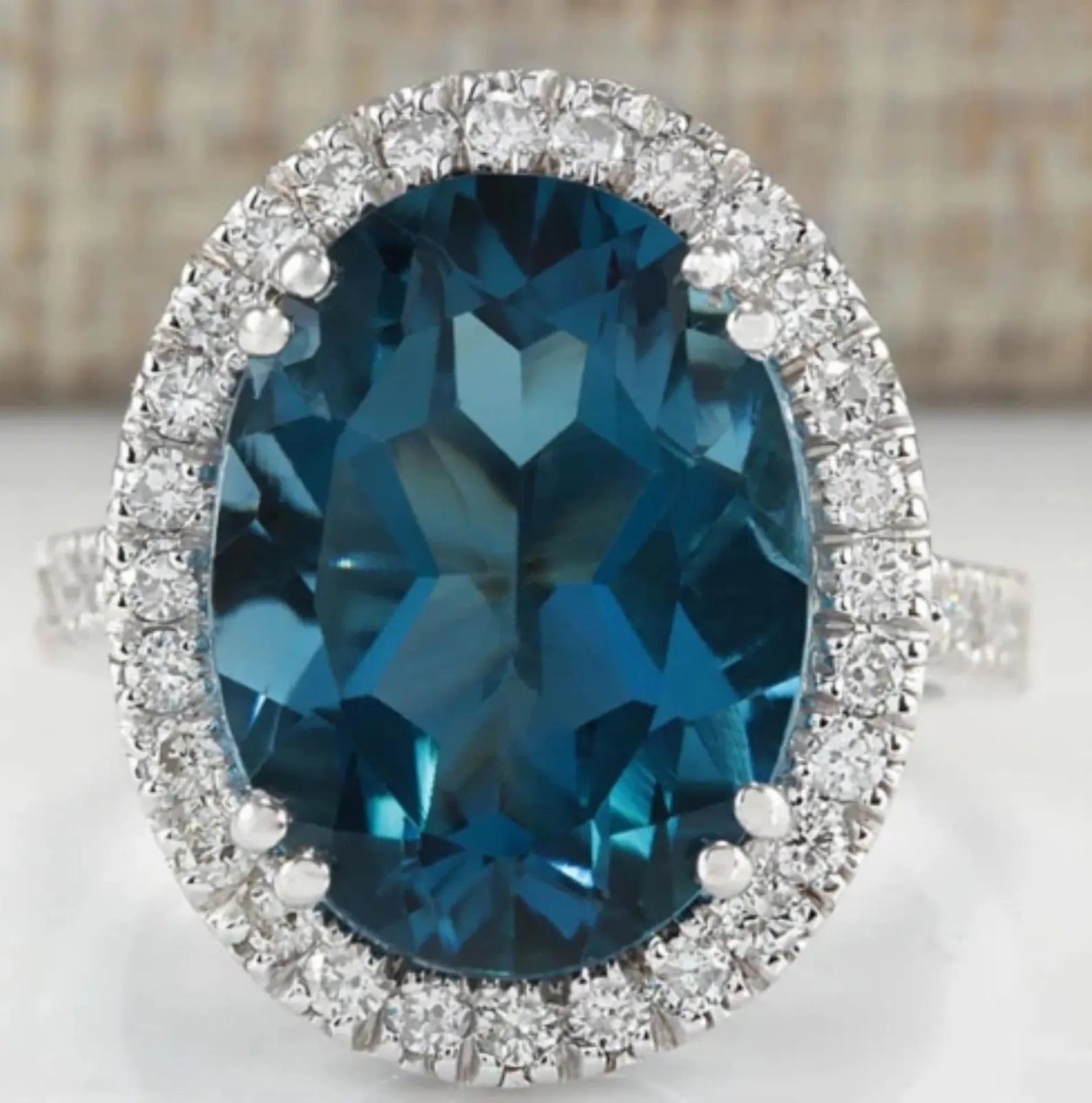 Stunning London Blue Topaz oval engagement ring with a shimmering diamond halo, perfect for special occasions.