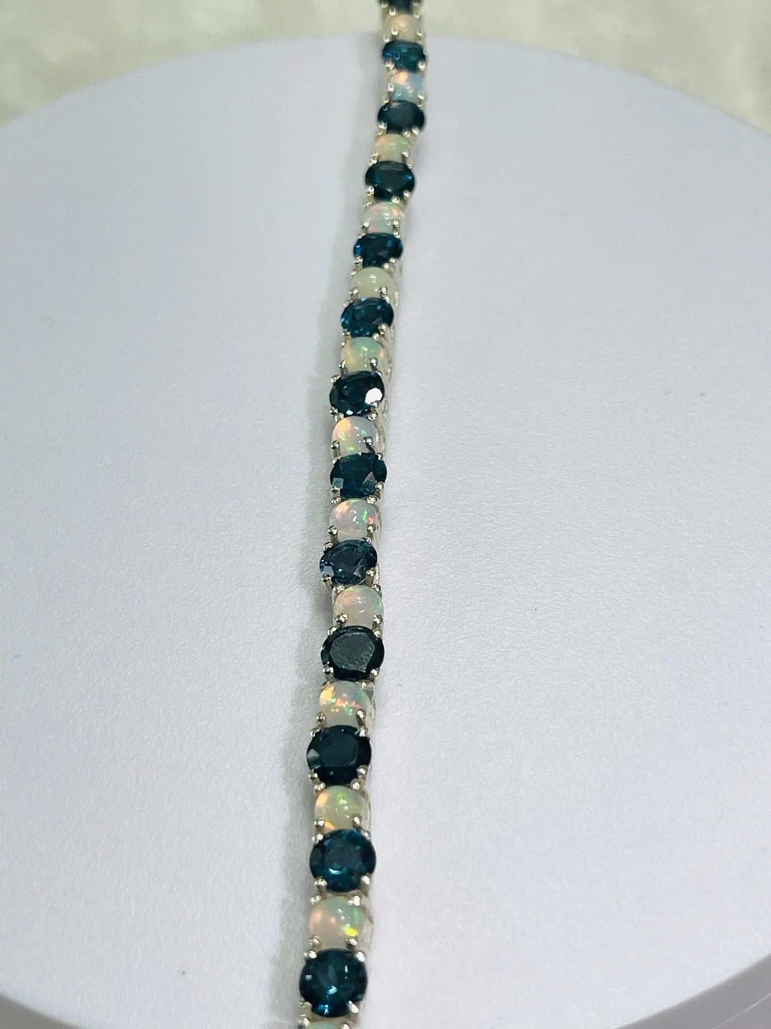 Full length view of a London Blue Topaz and Opal tennis bracelet, highlighting its continuous gem line.