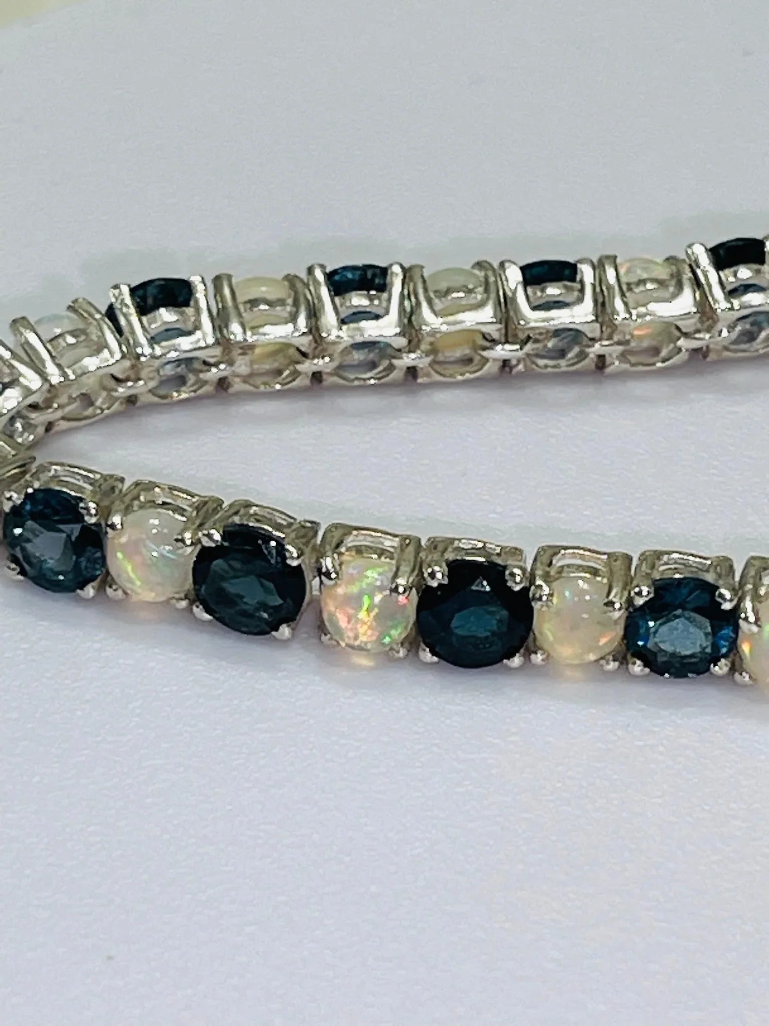 London Blue Topaz and Opal tennis bracelet with brilliant gemstones and a polished silver setting.