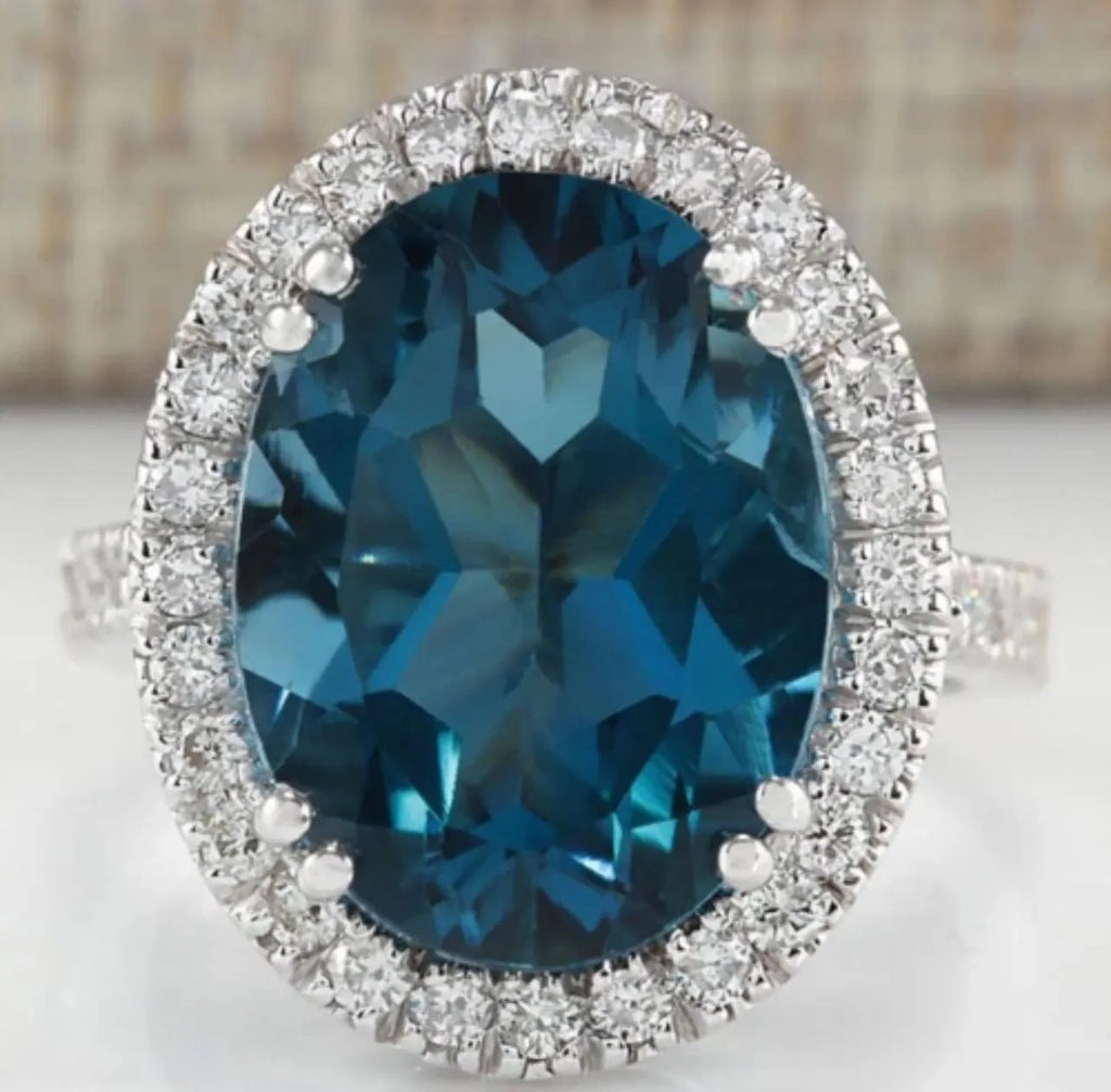 Close-up of an oval London Blue Topaz halo ring with brilliant white accent stones, highlighting gemstone clarity.